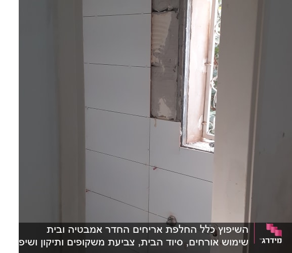 שירותים בשיפוץ עם אריחים חדשים וקיר חשוף